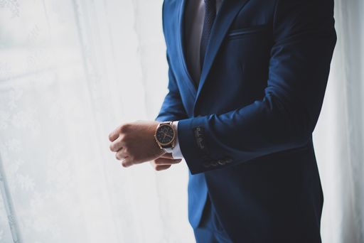 A vertical shot of a handsome businessman with a blue suit against a white background