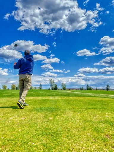A vertical shot of a man playing golf at a lush green golf course in Venango, Pennsylvania