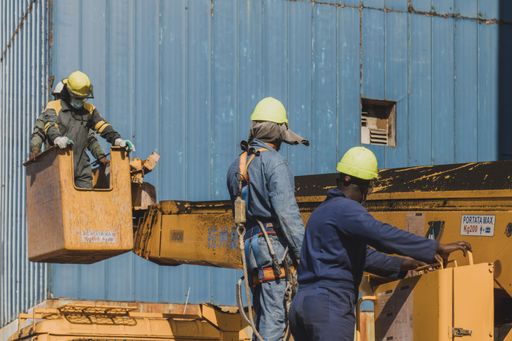 A rear view of two male workers working on a construction site
