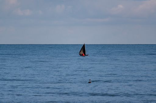 A beautiful shot of a small sailing boat in an open sea during daytime