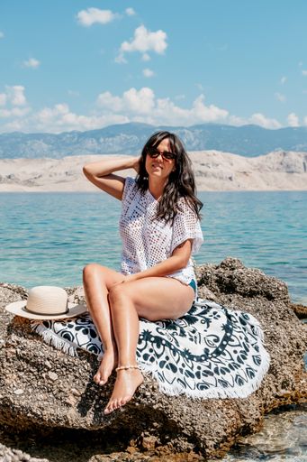 A vertical shot of a beautiful sexy woman with sunglasses enjoying summer sea