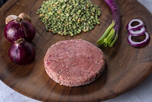 A closeup shot of raw healthy cutlet with ingredients on a wooden board