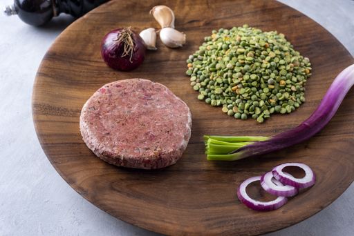 A closeup shot of raw healthy cutlet with ingredients on a wooden board