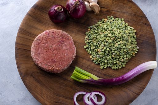 A closeup shot of raw healthy cutlet with ingredients on a wooden board