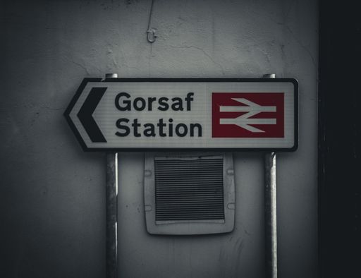 A sign with an arrow pointing in opposite directions, indicating the way to the Gorsaf station.