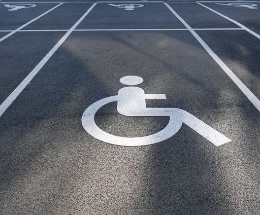 A handicap sign on the ground in a parking lot