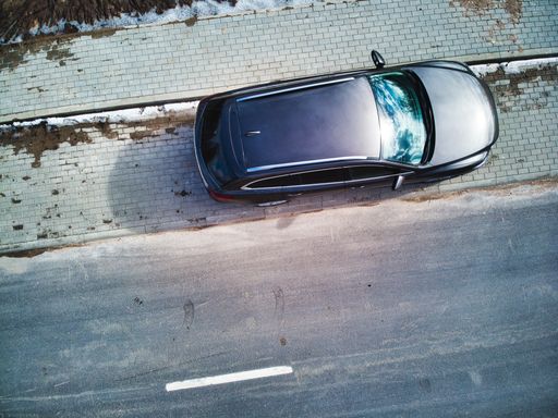 A top view of a car parked on a street on a sunny day