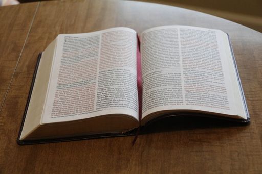 An open book with a bookmark on a wooden table