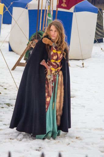 History hobbyst dressed as a medieval lady with a pistol