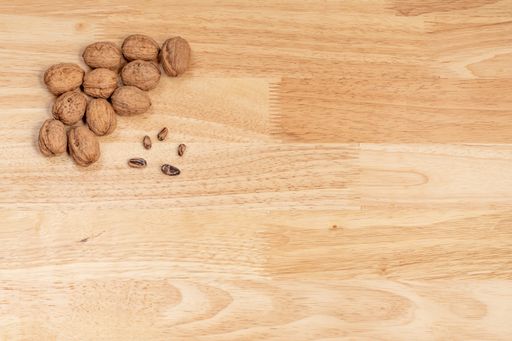 A top view of walnuts, and pine nuts on a wooden table