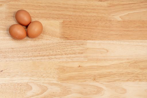 A top view of three eggs on a wooden table