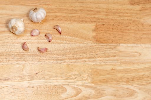 A top view of garlic and garlic cloves on a wooden table