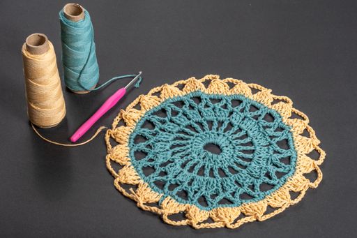 A crocheted piece hand-knitted of orange and green wool threads