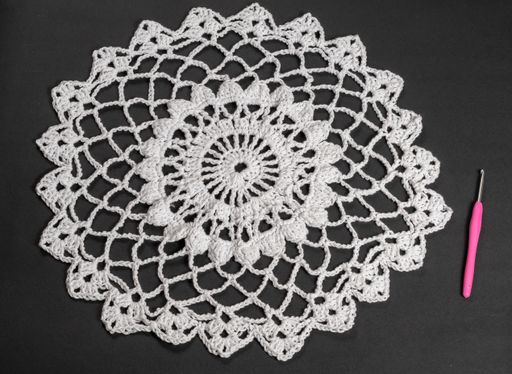 A closeup shot of a decorative wool piece knitted by hand with a crochet hook