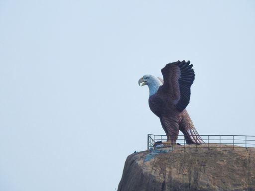 A side view of the huge statue of the bald eagle with its opened wings on the hill in Lepakshi