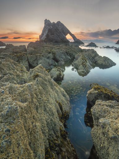 Sunset sky over rocky shoreline