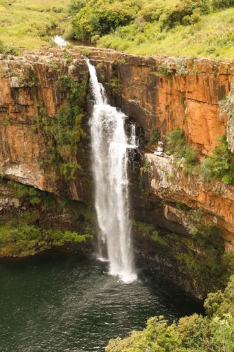 The Berlin Falls surrounded by rocks covered in greenery under the sunlight in South Africa