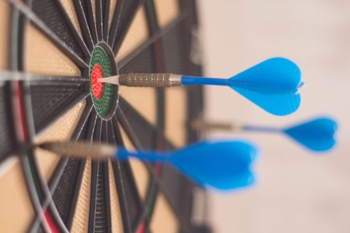 A selective focus shot of a dartboard with arrows