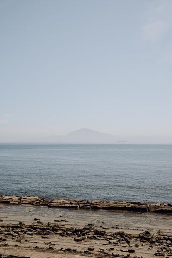 A beautiful seascape and rocky beach under a blue cloudless sky in Tarifa, Spain