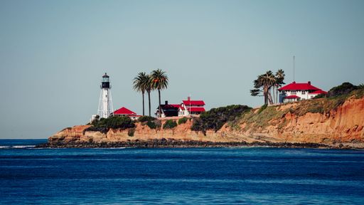 A lighthouse stands majestically in the middle of a vast body of water, located in the Point Loma peninsula of San Diego, California