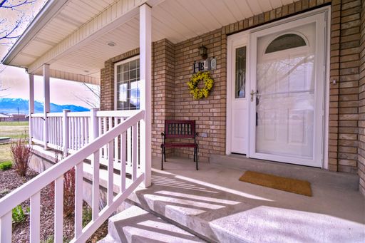 A beautiful view of the entrance column porch with white wooden railings