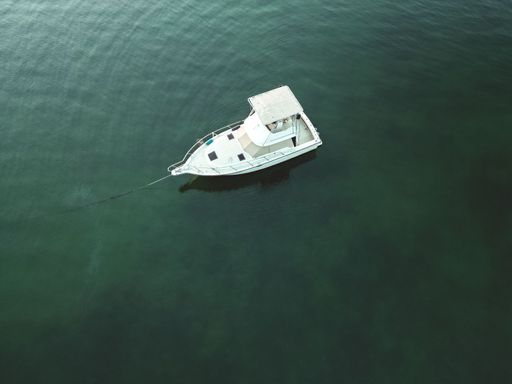 An aerial shot of a boat sailing in tranquil waters on a placid lake.