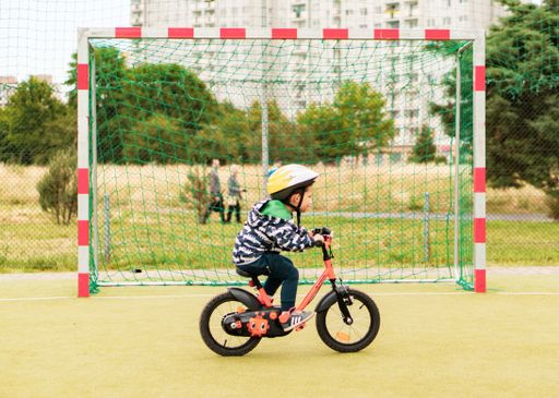 Young Polish Caucasian boy wearing a safety helmet and practicing riding a bike.