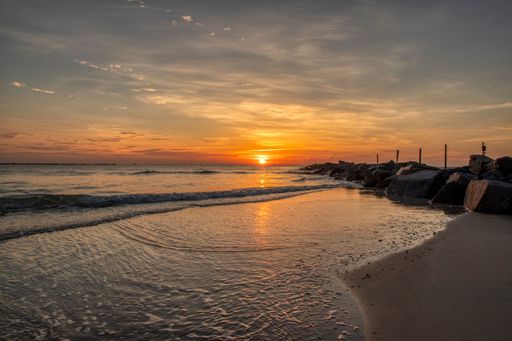 A beautiful sunrise from the beach with waves coming in and washing  he shore in Sebastian Inlet