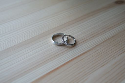 A closeup shot of two wedding rings on a wooden table