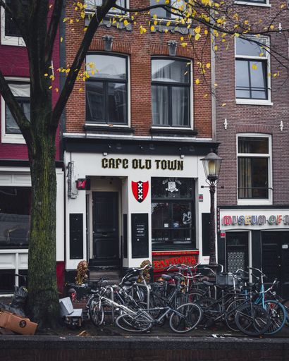 Amsterdam, Netherlands - November 27 2022: Bicycles parked outside Cafe Old Town, a bar in the red light district of Amsterdam.