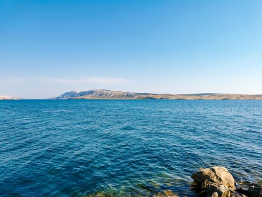 Beautiful summer scenery with arid coastline in background of blue sea. Amazing landscape with sea and coast in summer on Pag Island in Croatia.