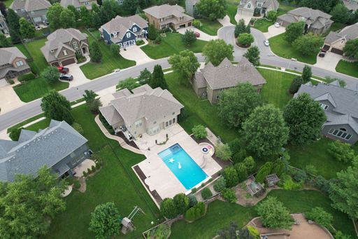Aerial view of a residential home with a swimming pool in a suburban area