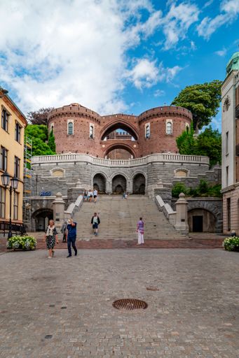 A street in Helsingborg with pedestrians passing by beautiful vintage buildings.