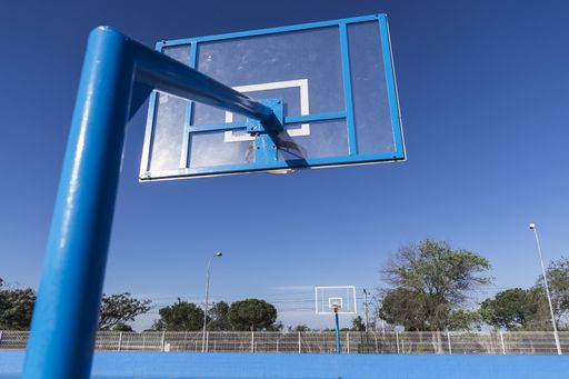 A closeup shot of a basketball hoop and the court painted in blue