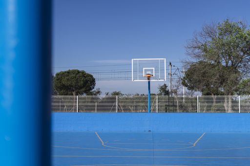 A closeup shot of an outside basketball court painted in blue