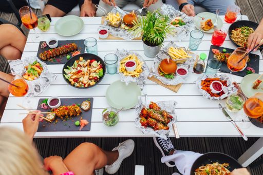 A group of people enjoying a meal together in an outdoor restaurant in summer