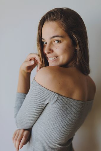 A vertical shot of a Spanish female posing on white background