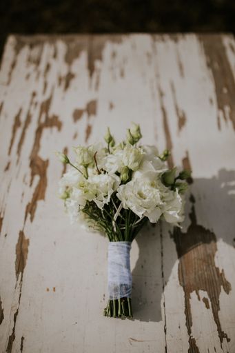 A vertical shot of a bridal flower bouquet on a wooden surface