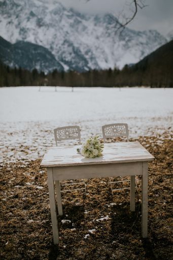 A wooden white table for a wedding ceremony in a snowy area