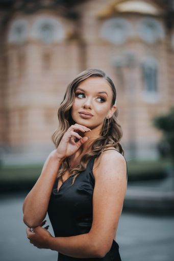 An attractive Caucasian woman wearing an evening dress posing in the street
