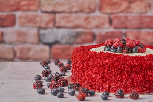 A closeup of red velvet cake with raspberries, blueberries, and blackberries