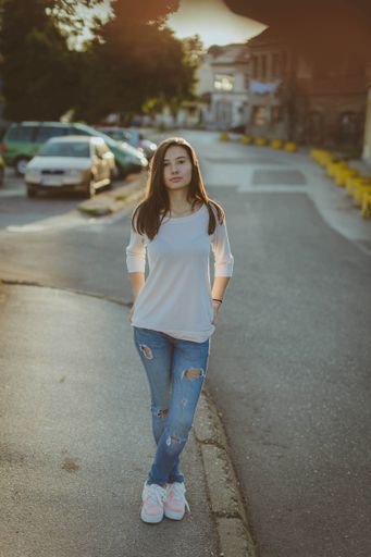 A shallow focus shot of a young beautiful Caucasian female wearing casual clothes posing at camera