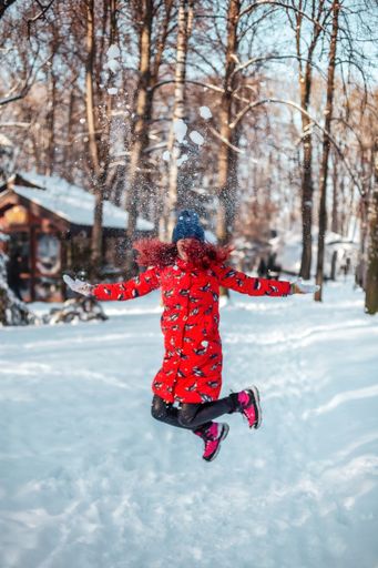 A happy young woman jumping in the snow