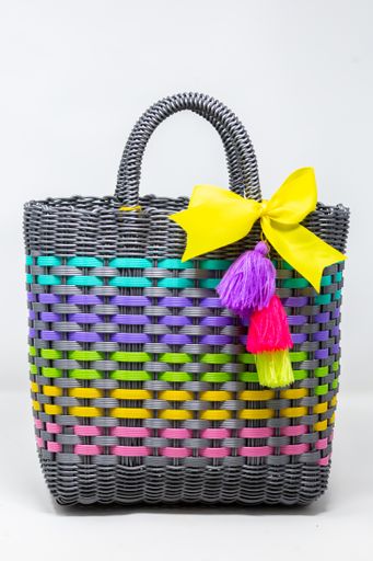 A vertical shot of a gray wicker bag with colorful patterns isolated on a white background