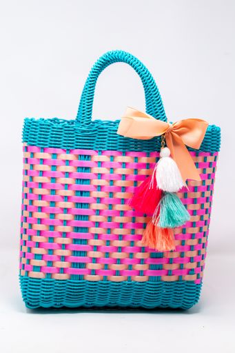 A vertical shot of a wicker bag with colorful patterns isolated on a white background