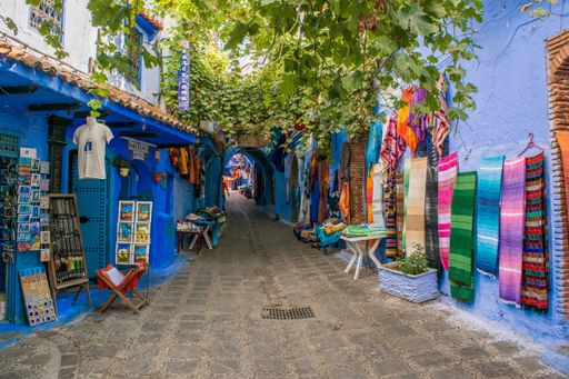 A closeup of colorful fabrics and scarfs displayed in a narrow street in Chefchaouen town, Morocco
