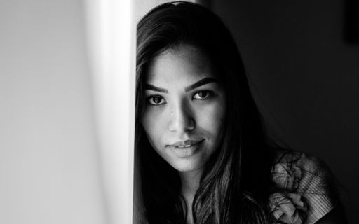 A closeup shot of a beautiful Hispanic girl posing on a black background