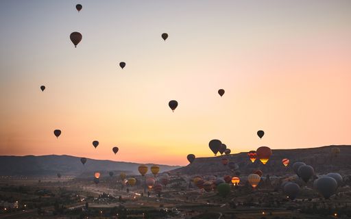 The mesmerizing view of the hot air balloons in the rocky mountains of Kapadokya, Turkey