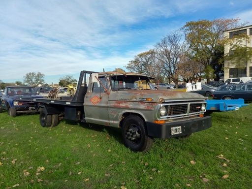 Old worn unpainted 1960s Ford F 350 Diesel flatbed pickup truck on the lawn. Classic car show. Side view. Copyspace