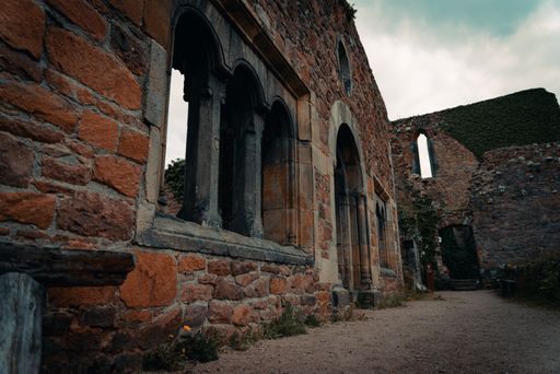 The ruins of an old brick structure with arching window holes in the walls